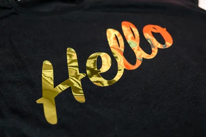金箔シートでHelloの筆記体を圧着した黒いTシャツ